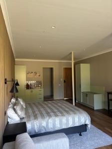 a bedroom with a large bed and a couch at Gala 1 - The Old Coolstore in Merricks North