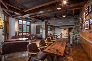 a restaurant with wooden tables and chairs and windows at YangShuo Coco Garden Villa-Western food&English Guide in Yangshuo