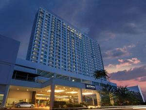 a large building with a car parked in front of it at Pullman Kuching in Kuching