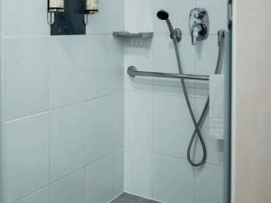 a shower in a bathroom with a shower head at Novotel Lima San Isidro in Lima