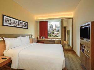 a bedroom with a large white bed and a window at ibis Bengaluru City Centre - An Accor Brand in Bangalore