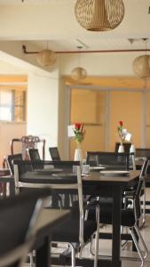 a dining room with tables and chairs with flowers on them at Zhongkebole Suites in Baguio