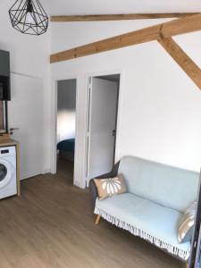 a living room with a couch and a bed at Studio indépendant face à la forêt in Aureilhan