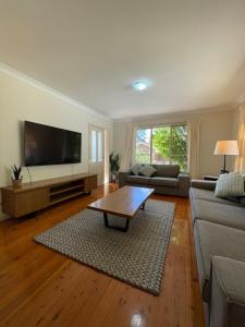 a living room with a couch and a coffee table at Ficus Cottage - 3 Bed 2 Bath in Wentworth Falls