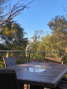 a bird standing on a deck with a table at Ficus Cottage - 3 Bed 2 Bath in Wentworth Falls