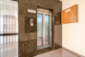 a glass door in a room with a wall at Super Hotel O Navasari Bus Terminal Formerly Jay Shankar in Sisodra
