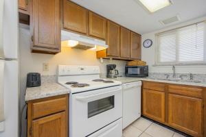 a kitchen with white appliances and wooden cabinets at Driftwood Towers 5E in Gulf Shores