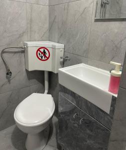a bathroom with a white toilet and a sink at Helios in Ioannina