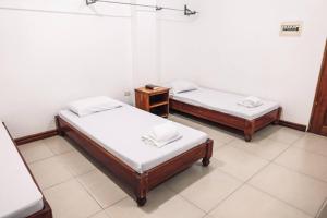 a room with two beds and a night stand at HOTELINDA Suites in Vigan