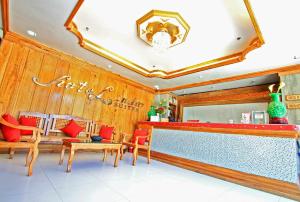 a restaurant with a bar with red chairs and tables at HOTELINDA Suites in Vigan