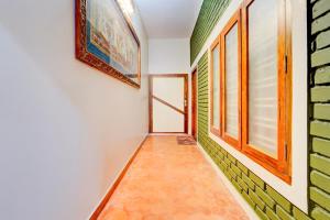 a hallway with green and white walls and windows at Super Hotel O CSIR Pappanamcode Formerly Ambadi Guest House in Poojapura