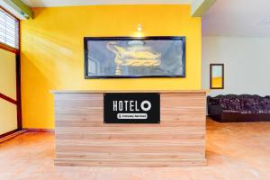 a hotel room with a sign on a yellow wall at Super Hotel O CSIR Pappanamcode Formerly Ambadi Guest House in Poojapura