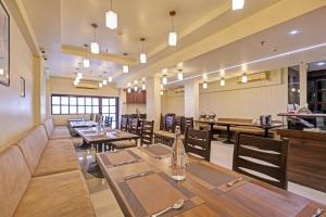 a dining room with wooden tables and chairs at Townhouse Vadodara Railway Station Road Formerly Hotel Raajpath in Vadodara