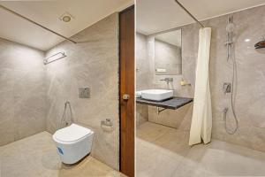 a bathroom with a toilet and a shower and a sink at Townhouse Vadodara Railway Station Road Formerly Hotel Raajpath in Vadodara