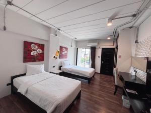 a room with two beds and a desk and a television at Diary Suite in Nakhon Pathom +47 photos