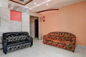 a couch and a chair in a room at Hotel O Tarapith Temple Formerly Prerana 2 in Tarapith