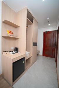 a room with a kitchen with a counter and a red door at Eden Luxury Hotel in Thái Bình