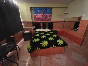a bedroom with a bed with a black and green blanket at EL BOSQUE Hostal in Chiclayo