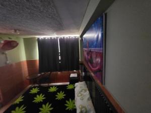 a room with a staircase with a chair and a painting at EL BOSQUE Hostal in Chiclayo