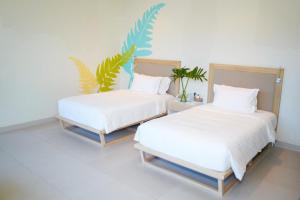 two beds sitting next to each other in a room at Costa Pacifica Baler in Baler +32 photos