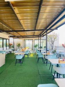 a cafeteria with tables and chairs and windows at Diary Suite in Nakhon Pathom