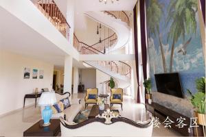 a living room with a staircase with a couch and chairs at Hanamitsu Hotel & Spa in Garapan