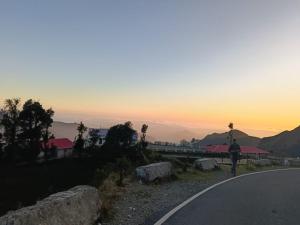 a person riding a bike down a road at sunset at Lekhwar in Chamba