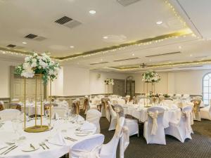 a banquet hall with white tables and chairs at Mercure Exeter Southgate Hotel in Exeter +144 photos