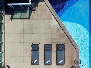 an overhead view of a swimming pool with four chairs at Mercure Maceio Pajuçara in Maceió