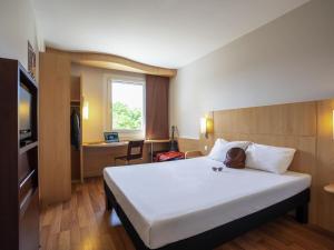 a hotel room with a large bed and a desk at Ibis Hotel Plzeň in Pilsen +126 photos