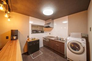 a kitchen with a washing machine and a sink at 民泊-天- in Beppu