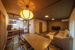 a living room with a dining room table and a kitchen at 民泊-天- in Beppu