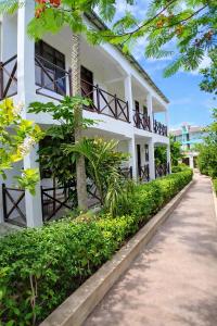 a white building with a pathway in front of it at Majani Breeze Zanzibar in Nungwi