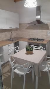 a kitchen with a table with chairs and a sink at La Cilinella del Salento in Copertino