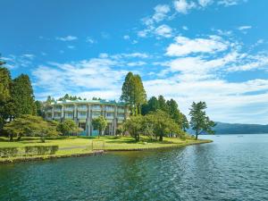 a large building on the shore of a lake at The Prince Hakone Lake Ashinoko in Hakone