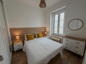 a bedroom with a white bed with two yellow pillows at Sol e Rio in Setúbal