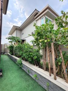 a house with trees in front of it at Bluesky Villa Bang Sare in Bang Sare