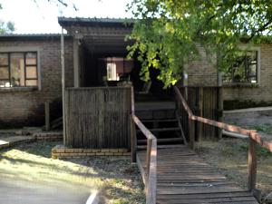 a wooden staircase leading to a building with a gate at Bloemhof Riverside Chalets in Bloemhof