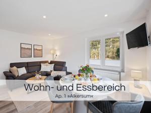 a living room with a couch and a table at Entspannter Nordsee-Urlaub in naturnahen Ferienwohnungen im Haus Tide in Böhl +58 photos