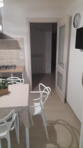 a kitchen with a table and chairs and a clock at La Cilinella del Salento in Copertino +16 photos
