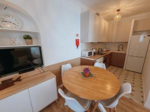 a kitchen with a wooden table and a dining room at Sol e Rio in Setúbal