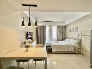 a bedroom with a bed and a table in front of it at Suite Escape Mactan , condo with balcony near Mactan Newtown and Mactan Airport in Mactan +13 photos