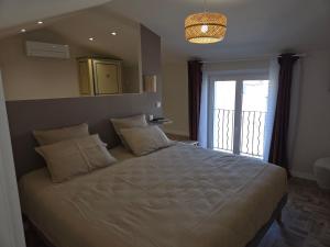 a bedroom with a large white bed with a window at Le pommier in Aiglun