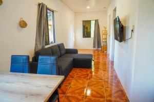 a living room with a couch and blue chairs at Aman House in San Vicente