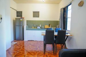 a kitchen with a table and chairs and a refrigerator at Aman House in San Vicente