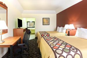 a hotel room with two beds and a desk at Super 8 by Wyndham Fairfield Tx in Fairfield
