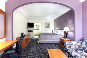 a hotel room with a bed and a desk at Super 8 by Wyndham Fairfield Tx in Fairfield