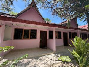 a pink and white house with a porch at Harmony - Havelock Island in Havelock Island