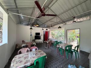 a room with tables and chairs and a television at Harmony - Havelock Island in Havelock Island