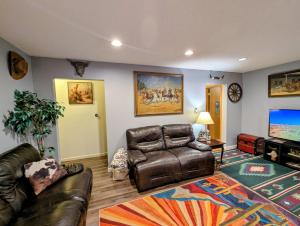 a living room with a leather couch and a flat screen tv at By State Fair 5 bedrooms 2 baths in Des Moines